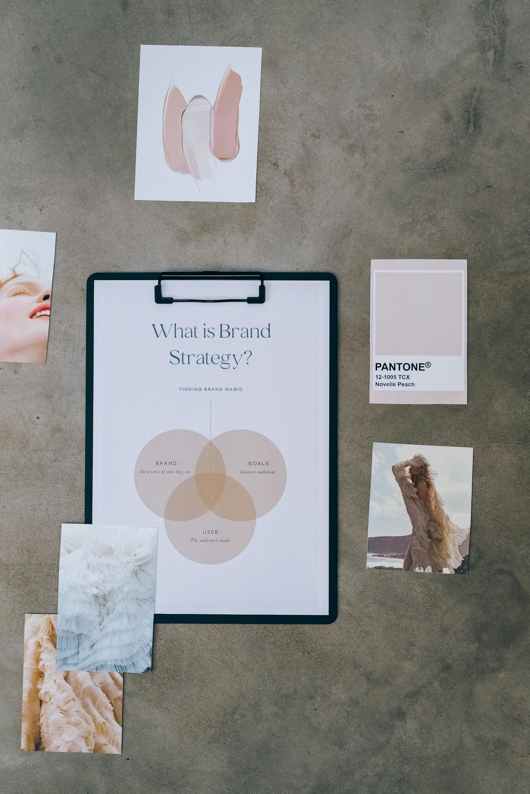 Flat lay of a brand strategy board surrounded by mood and color swatches on concrete.
